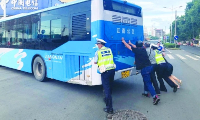 The Nanjinger - Nanjing Traffic Cop Famous after Pushing Bus with Burning Hands