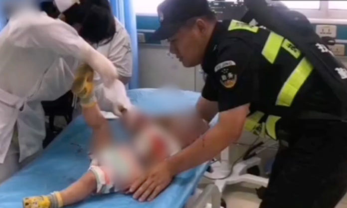 The Nanjinger - Cop Cradles Child Charging to ICU